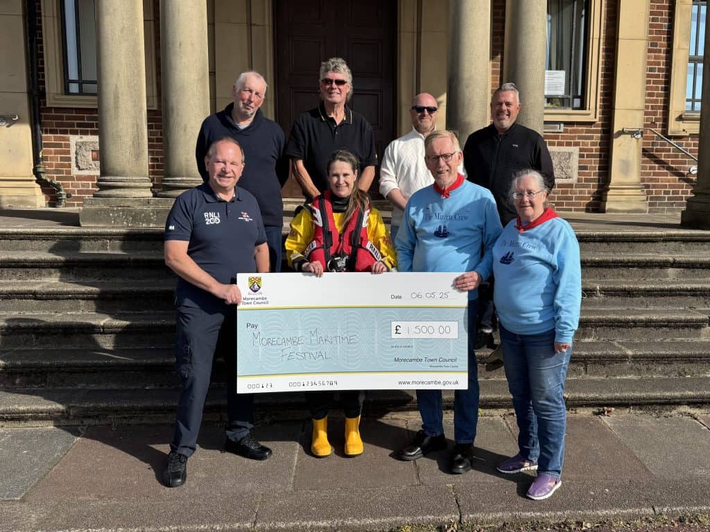 Representatives from the RNLI and The Mizzen Crew accept a cheque on behalf of Morecambe Maritime Festival, presented by Councillors John Livermore, Geoff Knight, Russell Walsh and Lee Bradbury